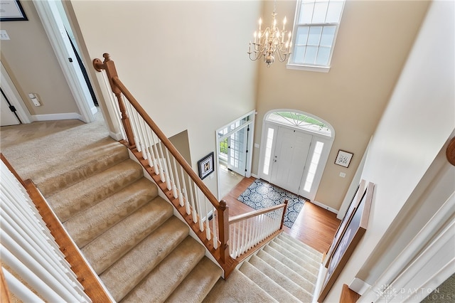 9378 Oak Brook Dr, Clearcreek Twp, OH 45458 - entryway featuring a towering ceiling, a chandelier, stairway, wood finished floors, and baseboards