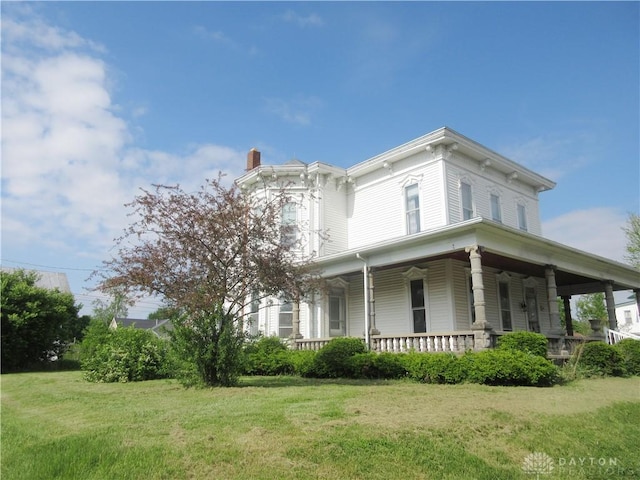 119 Orchard St, West Manchester, OH 45382 - view of front of home with a chimney, covered porch, and a front lawn