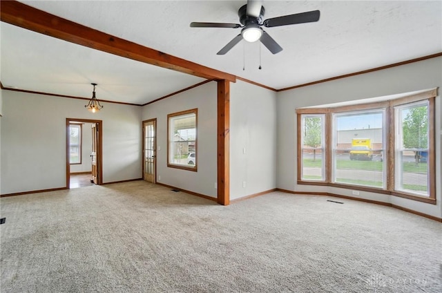 carpeted empty room featuring crown molding, healthy amount of natural light, and baseboards