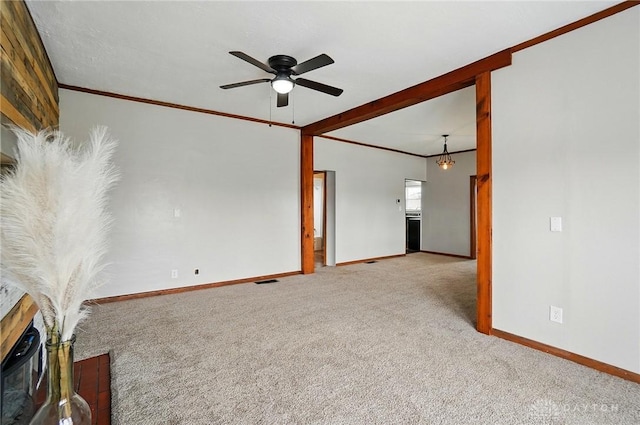 unfurnished living room with carpet flooring, baseboards, ceiling fan, and ornamental molding