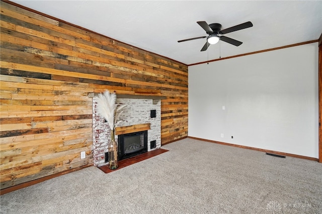 unfurnished living room with wood walls, baseboards, carpet floors, a ceiling fan, and a fireplace with flush hearth