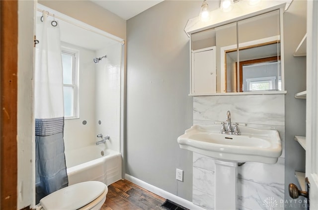 bathroom featuring shower / bath combo, toilet, wood finished floors, and baseboards