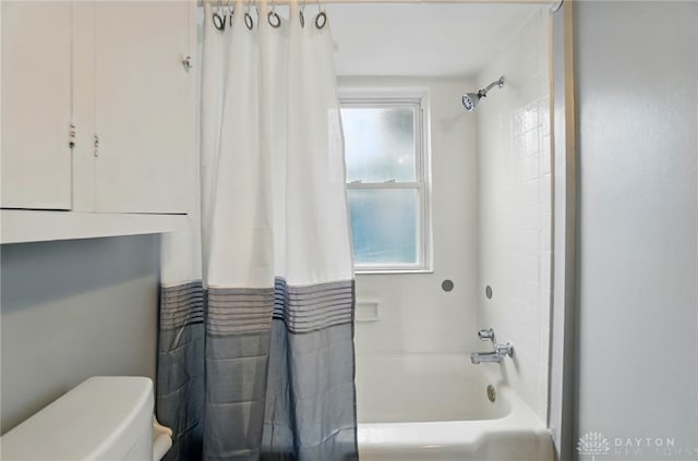 bathroom featuring shower / bath combo with shower curtain and toilet