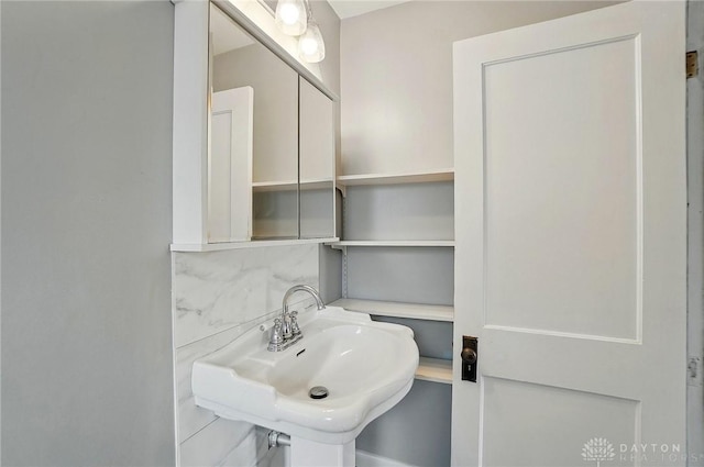 bathroom featuring decorative backsplash and a sink
