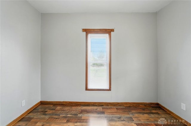 spare room featuring wood finished floors and baseboards
