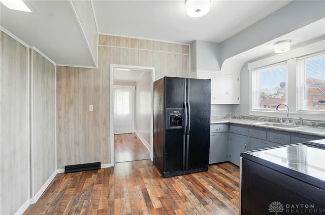 kitchen with black appliances, a sink, dark wood finished floors, light countertops, and ornamental molding