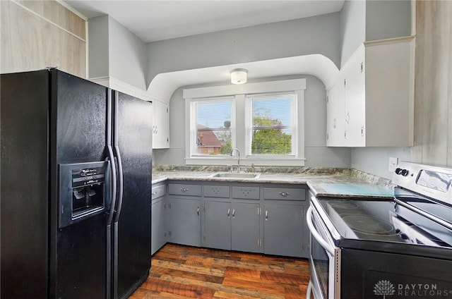 kitchen featuring black fridge with ice dispenser, electric range, a sink, gray cabinets, and dark wood finished floors