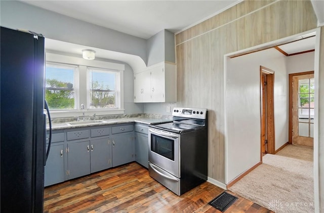 kitchen with stainless steel electric range, freestanding refrigerator, a sink, gray cabinets, and dark wood-style floors
