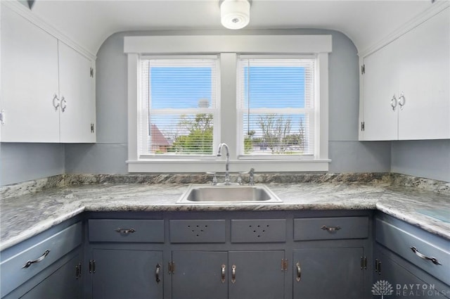 kitchen featuring a sink, white cabinets, and gray cabinetry