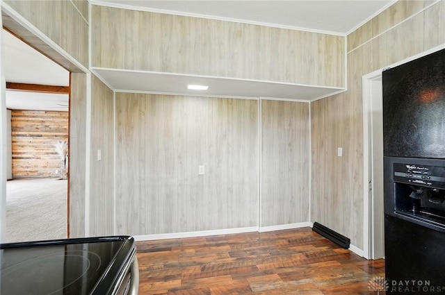 kitchen featuring black fridge, wood finished floors, wooden walls, electric stove, and baseboards