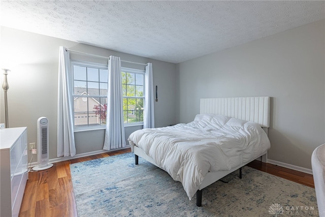 2540 Greenside Dr, Beavercreek, OH 45431 - bedroom featuring a textured ceiling, wood finished floors, and baseboards