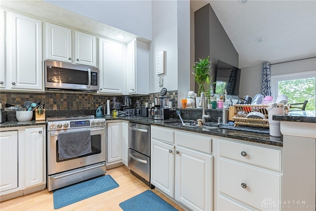 2540 Greenside Dr, Beavercreek, OH 45431 - kitchen with appliances with stainless steel finishes, lofted ceiling, backsplash, a sink, and dark stone countertops