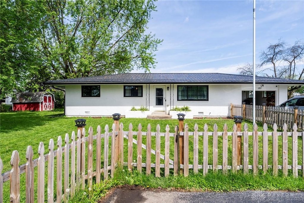 127 S College St, Sabina, OH 45169 - single story home featuring a storage shed, driveway, and stucco siding