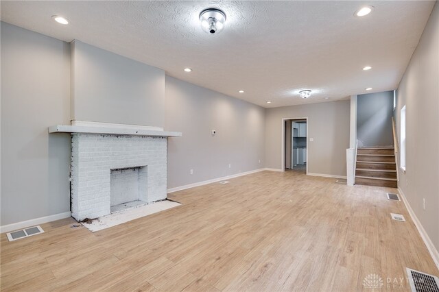 18241826 W Grand Ave, Dayton, OH 45402 - unfurnished living room featuring light wood-style floors, stairs, a fireplace, recessed lighting, and baseboards