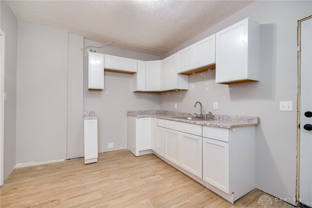 18241826 W Grand Ave, Dayton, OH 45402 - kitchen featuring a sink, light wood finished floors, white cabinetry, and a textured ceiling