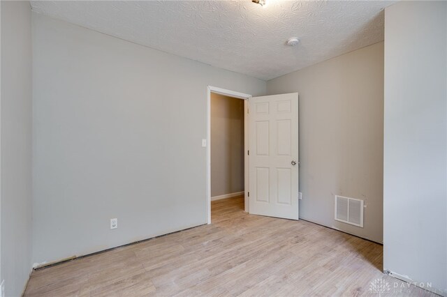 18241826 W Grand Ave, Dayton, OH 45402 - empty room with wood finished floors, a textured ceiling, and a smoke detector