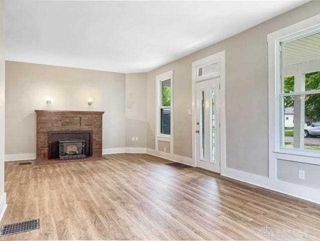 244 Windsor Ave, Urbana, OH 43078 - unfurnished living room with healthy amount of natural light, light wood finished floors, baseboards, and a fireplace