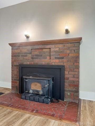 244 Windsor Ave, Urbana, OH 43078 - detailed view of baseboards, wood finished floors, and a brick fireplace