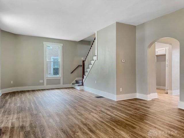 244 Windsor Ave, Urbana, OH 43078 - unfurnished living room with wood finished floors, arched walkways, and baseboards