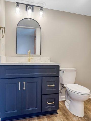 244 Windsor Ave, Urbana, OH 43078 - bathroom with wood finished floors, toilet, vanity, and baseboards