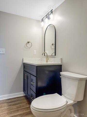 244 Windsor Ave, Urbana, OH 43078 - bathroom with toilet, vanity, wood finished floors, and baseboards