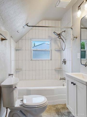 244 Windsor Ave, Urbana, OH 43078 - full bathroom featuring toilet, lofted ceiling, shower / bath combination, vanity, and tile patterned flooring