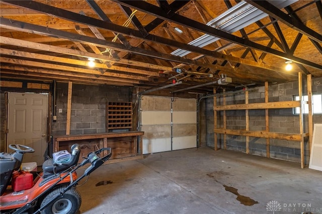 garage with a garage door opener and concrete block wall
