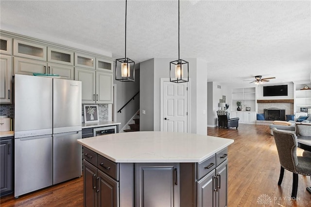 kitchen with freestanding refrigerator, a textured ceiling, gray cabinets, ceiling fan, and light countertops