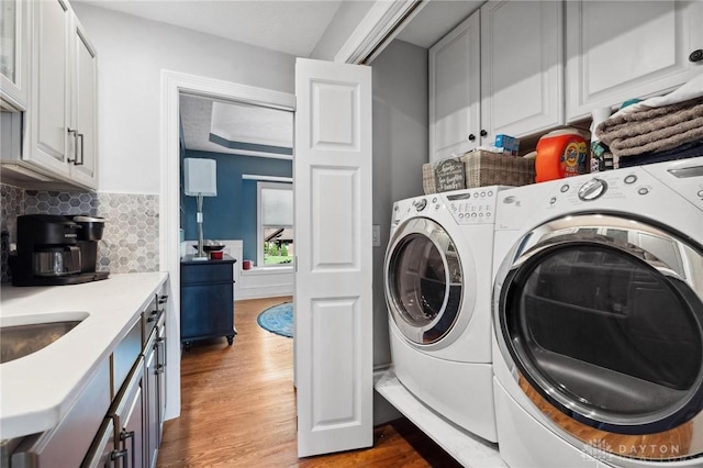 clothes washing area featuring wood finished floors and independent washer and dryer