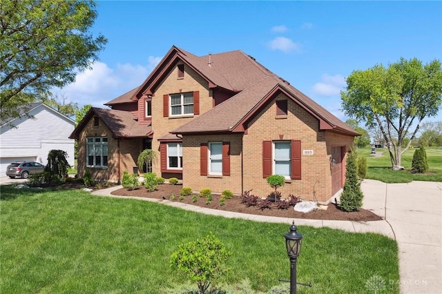 craftsman house featuring brick siding, a front yard, and a shingled roof