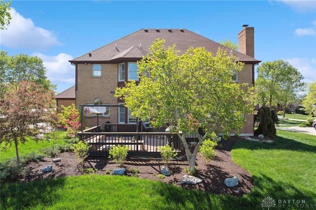 back of house with brick siding, a chimney, a lawn, and a wooden deck