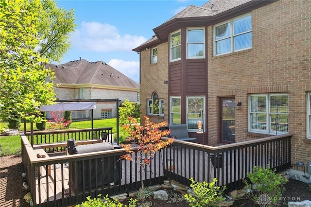 rear view of property with brick siding and a wooden deck