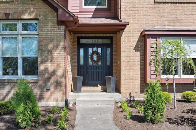 view of exterior entry featuring brick siding