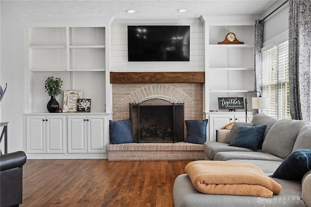 living area featuring dark wood-style flooring, a fireplace, recessed lighting, and built in shelves