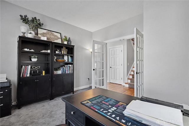 office featuring french doors, baseboards, and light carpet