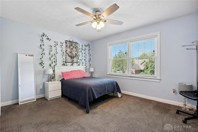carpeted bedroom featuring a textured ceiling, baseboards, and a ceiling fan