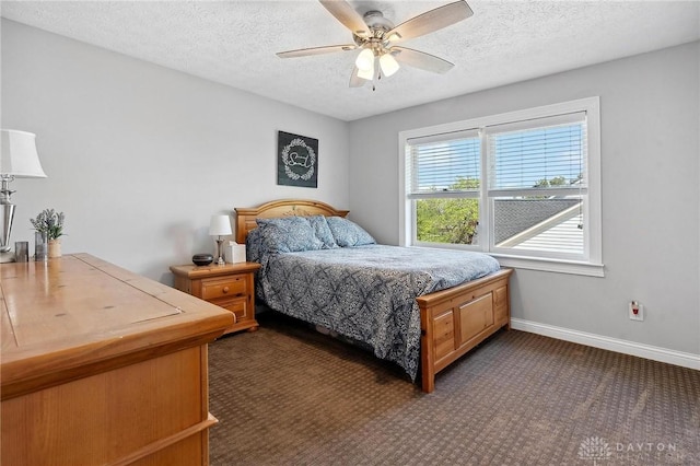 bedroom with a textured ceiling, dark colored carpet, a ceiling fan, and baseboards