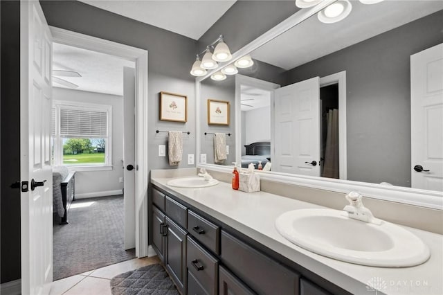 full bath featuring ensuite bathroom, double vanity, baseboards, and tile patterned flooring