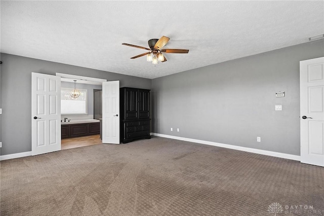 unfurnished bedroom with baseboards, carpet flooring, a textured ceiling, and connected bathroom
