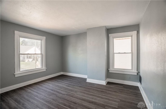 221 Virginia Ave, Dayton, OH 45410 - unfurnished room featuring dark wood-type flooring, healthy amount of natural light, and a textured ceiling