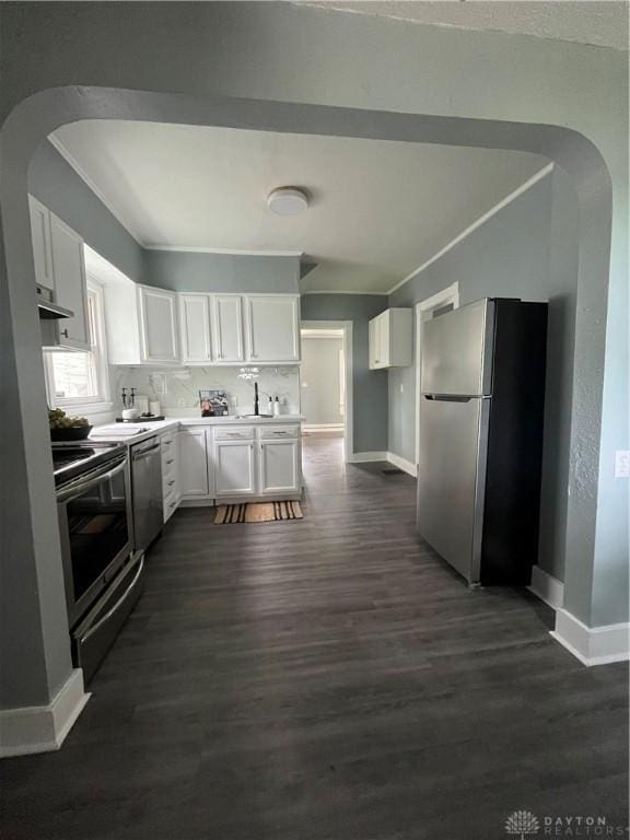 221 Virginia Ave, Dayton, OH 45410 - kitchen with stainless steel appliances, arched walkways, exhaust hood, dark wood-type flooring, and white cabinets