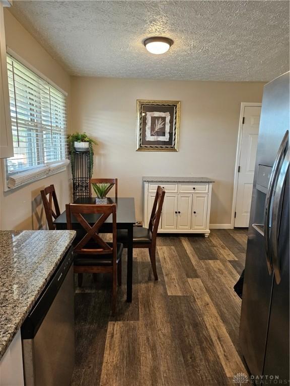 5107 Christy Ave, Dayton, OH 45431 - dining room with dark wood finished floors, a textured ceiling, and baseboards