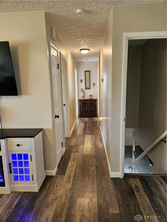 5107 Christy Ave, Dayton, OH 45431 - hallway with dark wood-style flooring, a textured ceiling, and baseboards