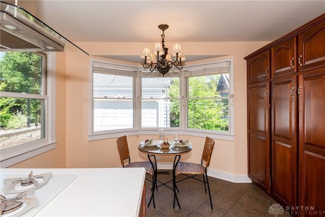135 E Dixon Ave, Oakwood, OH 45419 - dining space featuring a chandelier, dark tile patterned floors, plenty of natural light, and baseboards