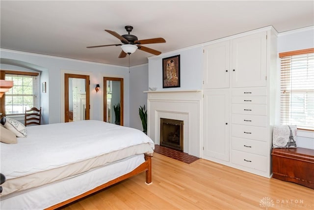 135 E Dixon Ave, Oakwood, OH 45419 - bedroom with light wood-style flooring, a fireplace, a ceiling fan, and connected bathroom