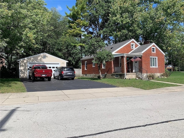 12 Harshman St, Brookville, OH 45309 - bungalow-style home featuring a detached garage, an outdoor structure, a front lawn, brick siding, and covered porch