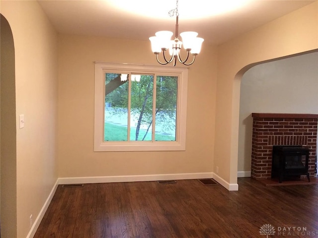 12 Harshman St, Brookville, OH 45309 - unfurnished dining area featuring arched walkways, a chandelier, wood finished floors, and baseboards