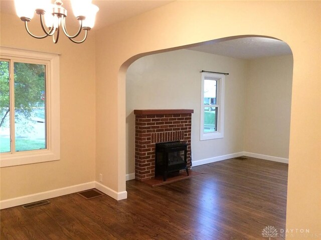 12 Harshman St, Brookville, OH 45309 - unfurnished living room with healthy amount of natural light, arched walkways, a chandelier, and wood finished floors