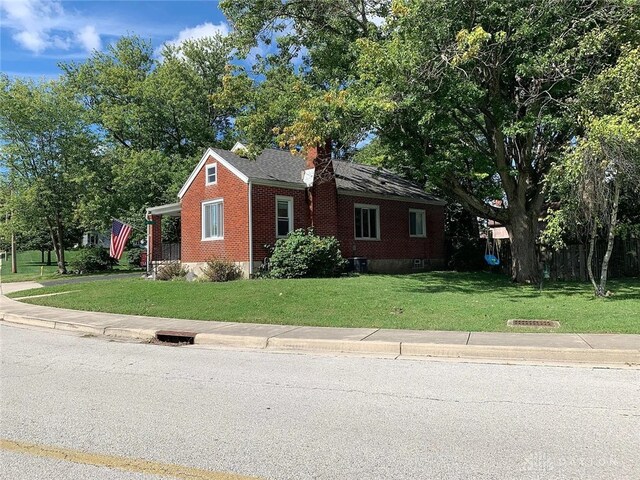 12 Harshman St, Brookville, OH 45309 - view of front of property featuring a front lawn and brick siding