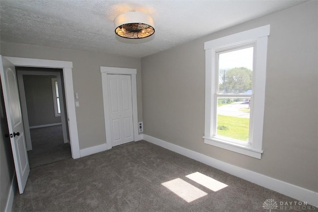 224 Suttman St, Miamisburg, OH 45342 - unfurnished bedroom with multiple windows, dark colored carpet, baseboards, and a textured ceiling